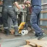Removal team using machinery skates to move heavy equipment safely during a professional removal